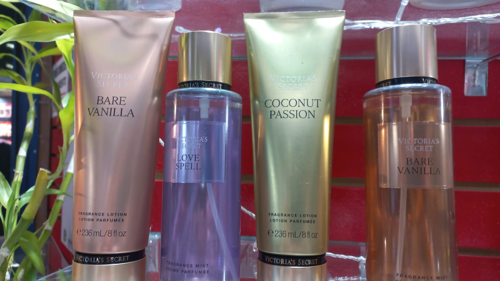 Perfumes e locoes Victoria's Secret com rotulos dourados e rosas na prateleira